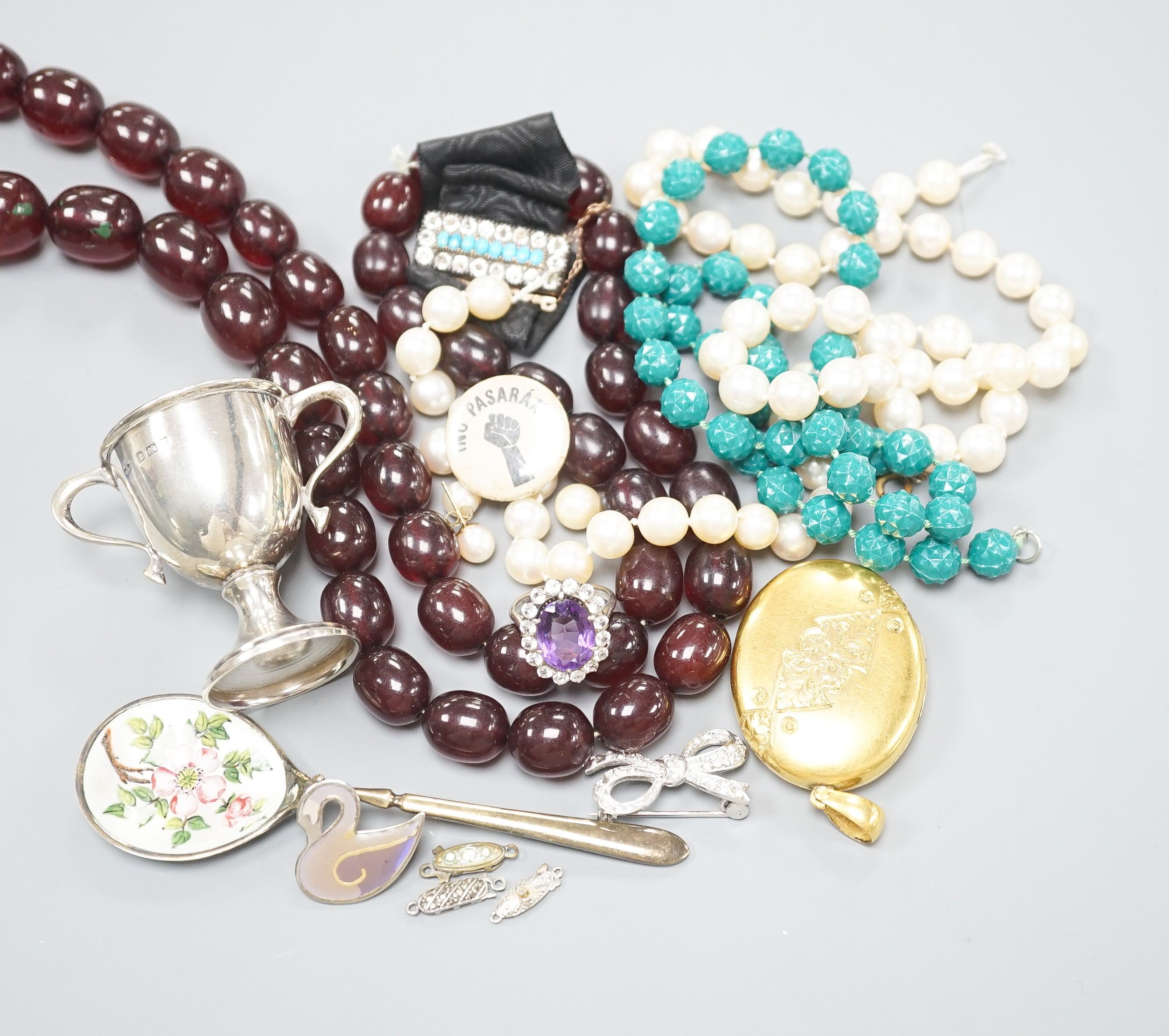 Assorted costume jewellery, etc. including small silver trophy cup, simulated amber necklace and git metal locket.